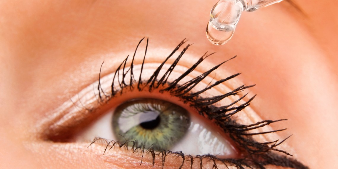 Closeup of eyedropper putting liquid into open eye