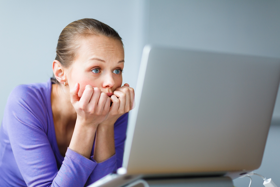 Working too hard - young woman working on a computer at an office, having sore back, being overloaded with work, sitting too much, putting too much stress on her eyes,..